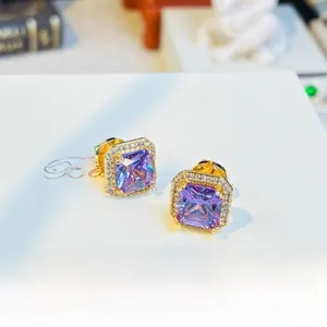 Detail of purple square gemstone earrings with sparkling crystal halo in gold setting