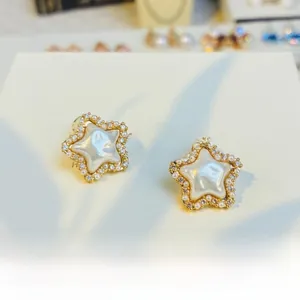 Detail of vintage star stud earrings with cream pearls and sparkling crystals in gold