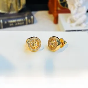 Close-up of gold-plated starburst compass stud earrings with crystals on a vintage card