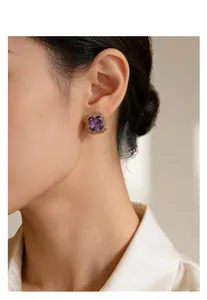 Macro shot of purple square gemstone earrings with vintage gold textured borders