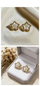 Detail view of vintage star stud earrings with white shell and mini pearls on velvet