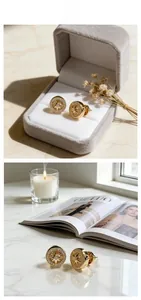 Detailed view of gold starburst compass stud earrings with crystals on velvet and marble