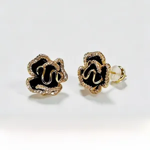 Detailed macro view of black enamel camellia earrings with sparkling pavé border