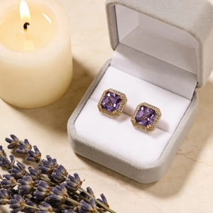 Square purple zircon halo earrings in gold settings displayed on a grey jewelry box