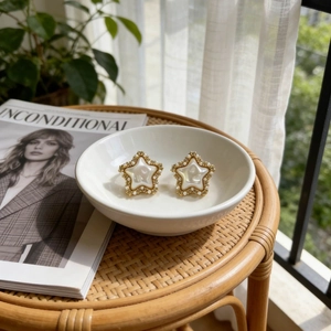 French vintage star earrings with gold-plated base and pearl accents in a ceramic bowl