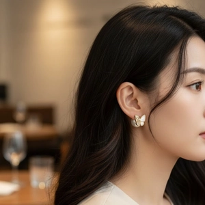Elegant butterfly earrings with gold metal, sparkling stones and white pearl drops