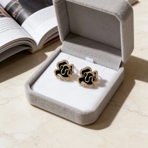 Black enamel camellia earrings with zircon trim in a premium gray velvet gift box