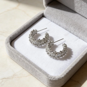 Elegant C-shaped silver stud earrings with sparkling pavé cubic zirconia in a jewelry box