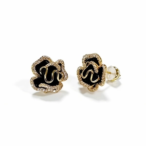 Golden camellia flower earrings with black enamel and sparkling pavé crystal accents