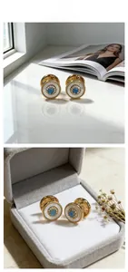 Detailed view of luxury turquoise and mother of pearl earrings with golden beaded edges