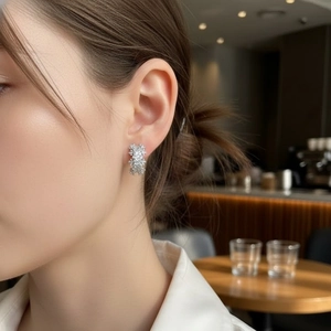 Elegant silver hoop earrings with sparkling floral zircon crystals on female model