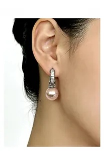 Close-up of pink baroque pearl earrings with micro-inlaid zircon hooks on female model