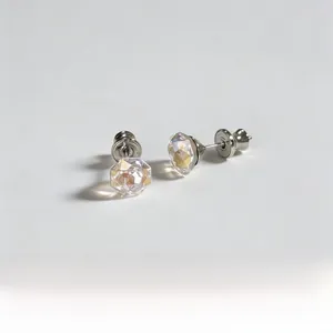 Macro view of multifaceted iridescent crystal earrings with silver plating and stud butterfly back