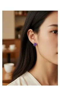 Gros plan d'un mannequin portant des boucles d'oreilles couronne avec zircon violet