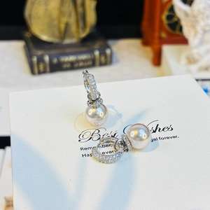 Macro detail of pink baroque pearl earrings with sparkling diamond-set silver hoops