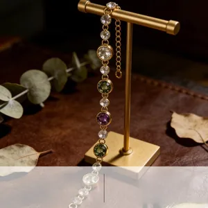 Close-up of a vintage colorful crystal bracelet on a gold display rack with leather background