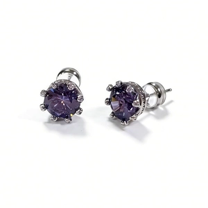 Détail macro de boucles d'oreilles couronne avec gemmes violettes rondes et serti argent