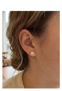 Close-up of champagne crystal stud earrings with classic claw setting worn on model