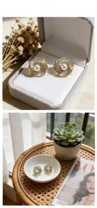Détail macro des boucles d'oreilles camélia avec perle blanche et cristaux brillants
