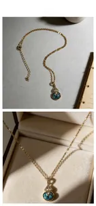 Détail du collier gourde dorée avec turquoise et cristaux dans un écrin à bijoux
