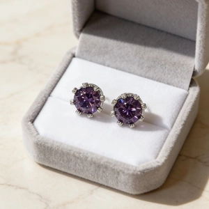 Boucles d'oreilles couronne en argent avec cristaux violets dans un coffret en velours