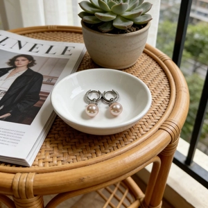 Elegant baroque pearl drop earrings with sparkling crystals in a white ceramic dish