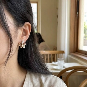 Vintage irregular crystal pearl petal earrings shown on model in warm ambient lighting