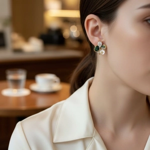 Vintage irregular crystal pearl flower stud earring worn by model in a cozy cafe setting