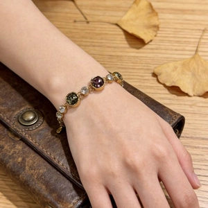 Luxurious gold-plated geometric bracelet with colorful crystals worn on a woman's wrist