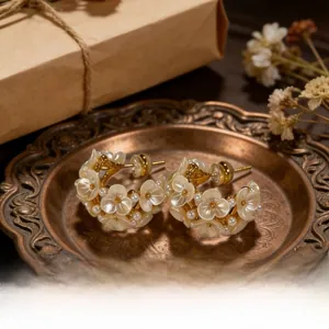 Detailed shot of gold-plated flower cluster earrings with mother-of-pearl and pearls