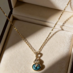Collier Wu Lou doré avec pierre turquoise et zircons sur un coffret à bijoux