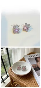 Detail of bear stud earrings with pink heart stone and sparkling purple zircon inlay