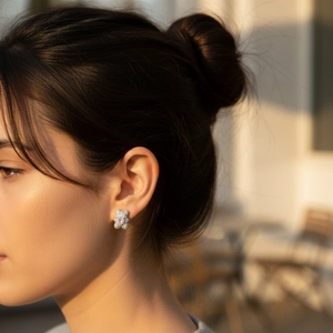 Teddy bear stud earrings with white zircons and pink heart stone worn by model in sunset