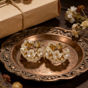 Elegant gold flower cluster earrings with mother of pearl and pearls on a vintage tray