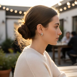 Elegant silver wide hoop earrings with paved white zircons worn by a model in sunlight