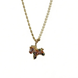 Asymmetric gold necklace with white pearls and a colorful zircon pony pendant
