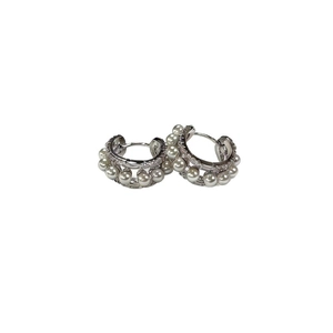 Elegant silver hoop earrings with pave diamonds and white pearls on white background