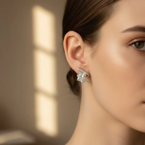 Elegant emerald-cut crystal stud earrings with pavé diamond detail worn by a model