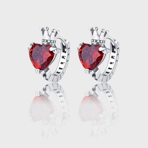 Detail of 925 silver heart crown earrings with vibrant red heart-shaped gemstone