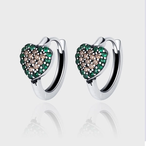 Détail de boucles d'oreilles cœur en argent S925 avec zircons verts et champagne