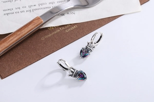 Detailed macro view of S925 silver crown earrings with iridescent heart-shaped gemstones