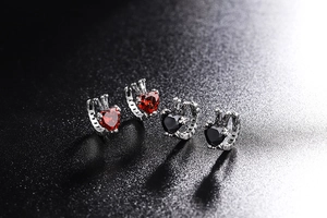 Close-up of S925 sterling silver heart earrings with crown detail in red and black