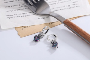 Macro shot of S925 silver crown earrings with rainbow heart-shaped gemstone charms