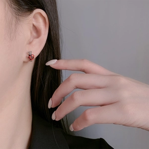 Close-up of S925 sterling silver stud earring with crown-set red heart-shaped gemstone