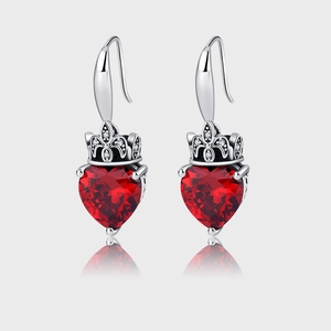 Macro detail of 925 silver earrings with crown setting and heart shaped red ruby stone