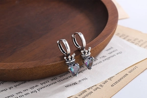 Macro detail of S925 silver crown earrings with heart-shaped colorful crystals