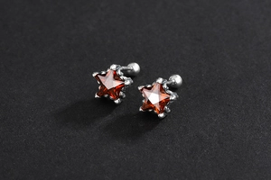 Vue détaillée des boucles d'oreilles étoile en argent S925 avec cristaux rouges rétro