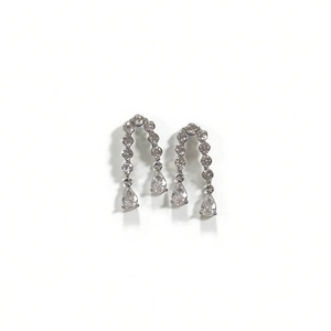 Détail des boucles d'oreilles argentées avec cristaux de poire et pompon scintillant