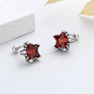 Vue macro de la boucle d'oreille étoile vintage en argent S925 avec une gemme rouge