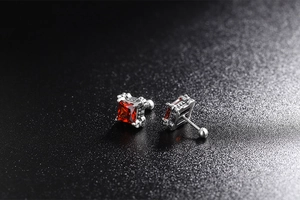 Detail of vintage silver stud earrings with red square stones and screw back closures
